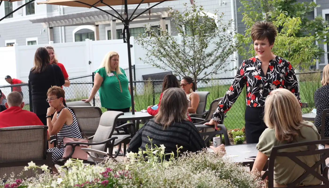 A group of professionals mingle in an outdoor business patio