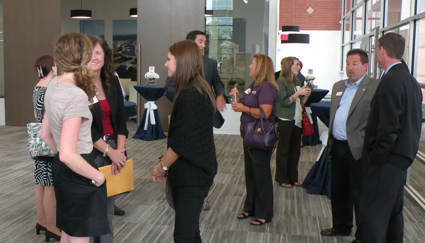 A group of business partners converse in an office lobby