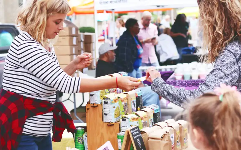 A patron purchases an item at the Cedar Rapids Farmers' Market