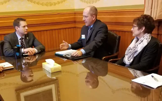 Elected officials discuss items at a desk