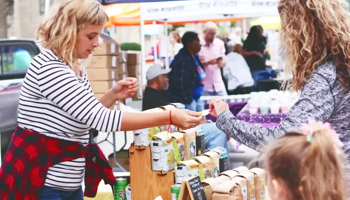 A patron purchases an item at the Cedar Rapids Farmers' Market