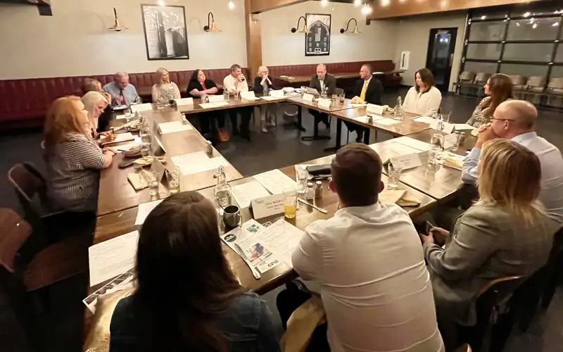 A group of business leaders work in a large conference room