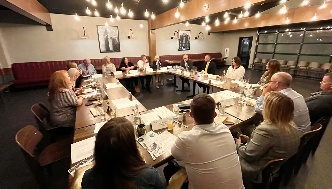 A group of business leaders work in a large conference room