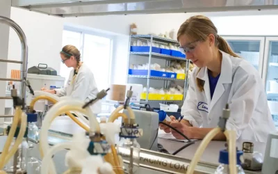 A young woman works with technical instruments in a laboratory setting