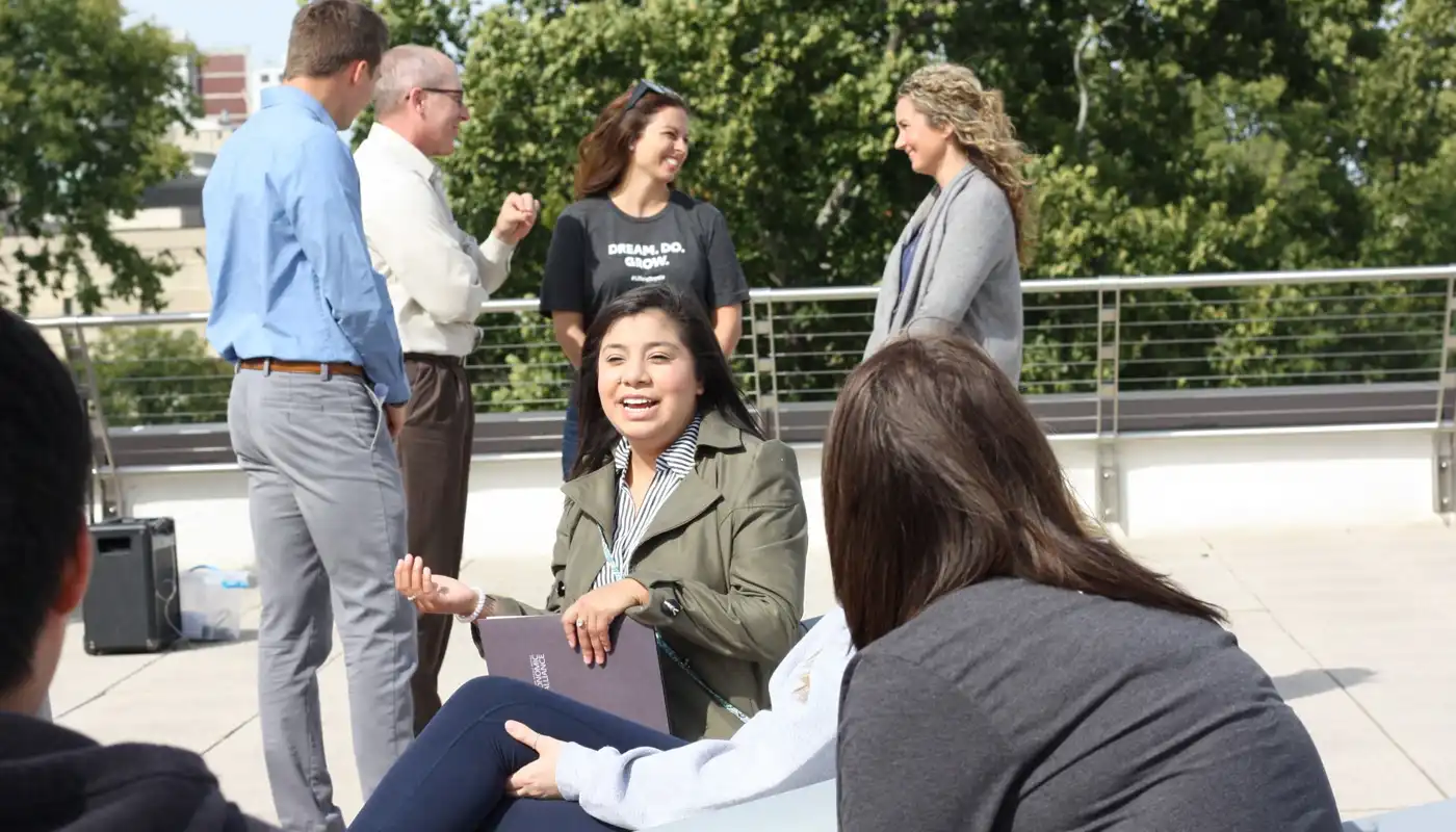 A group of young people talk in an outdoor place