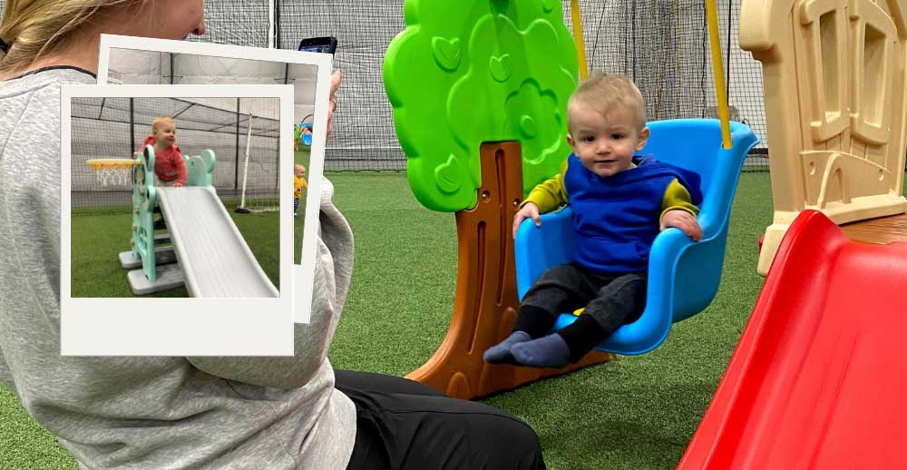 A kid swings on a blue swing