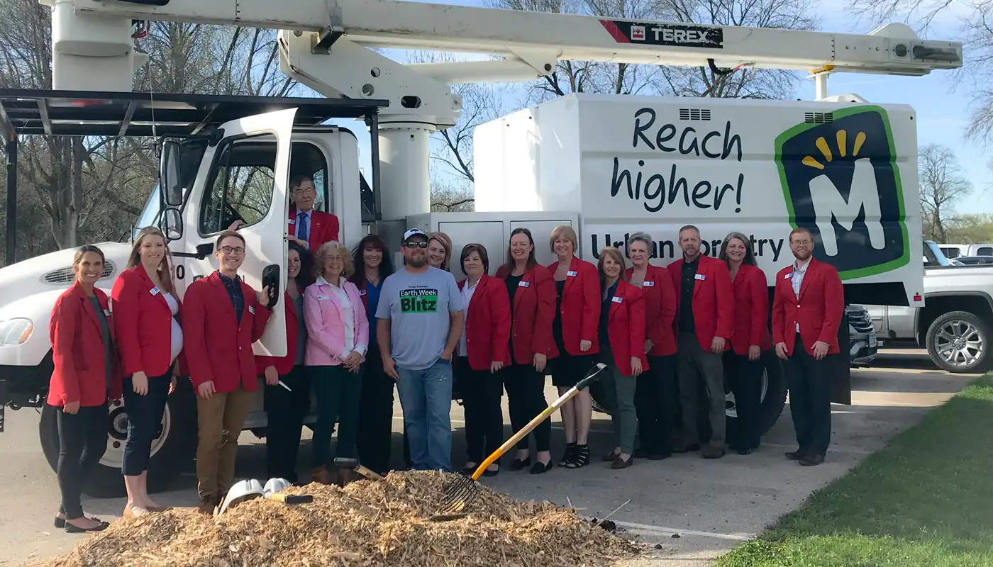 A group in red jackets stand in front of a work truck