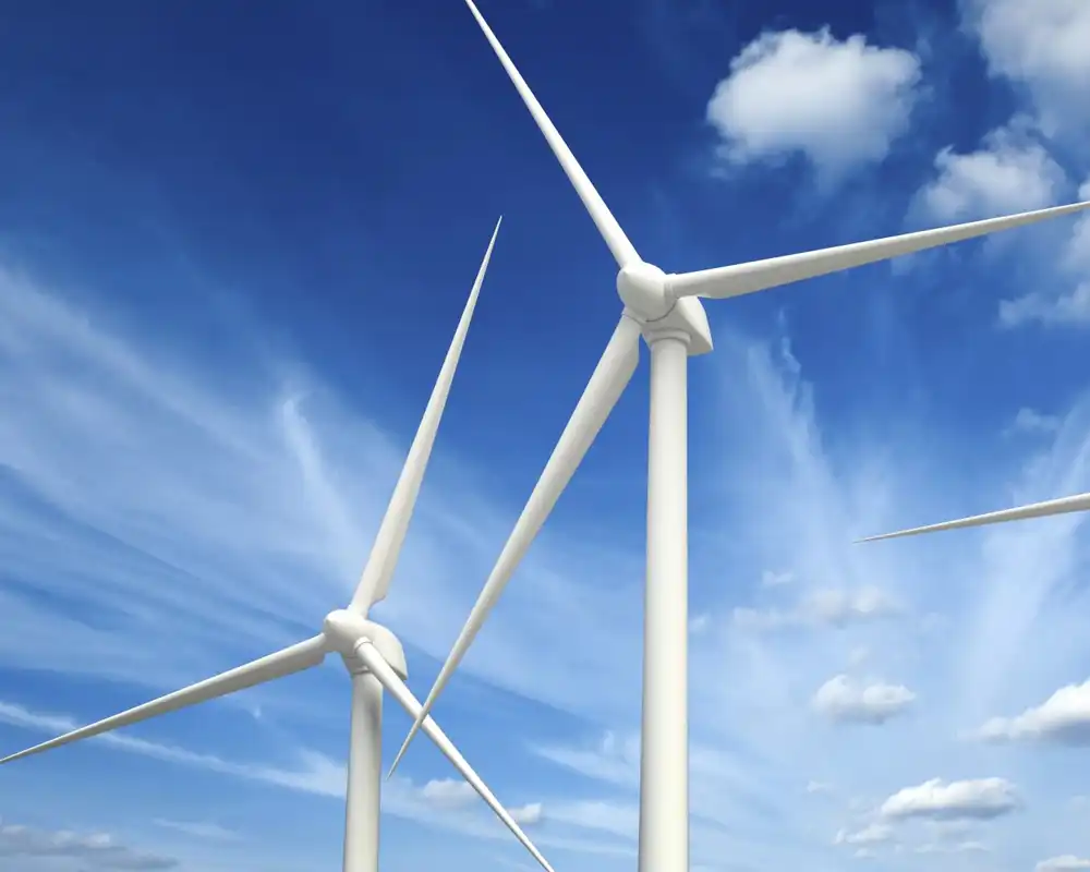 Large wind turbines against a crisp blue sky with clouds