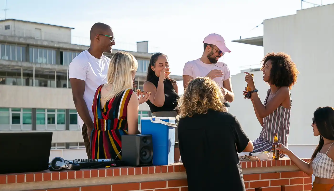 A diverse group of friends have an impromptu picnic on a rooftop