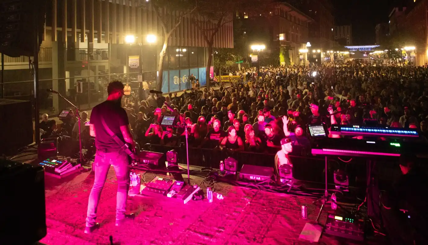 A band performs to a large crowd in the street