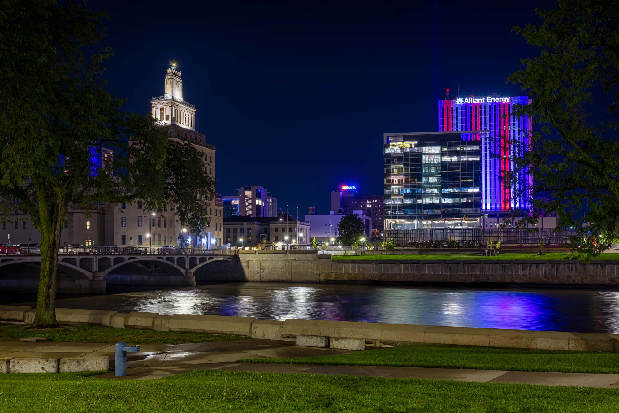 Downtown Cedar Rapids at night, lights reflecting over the Cedar River.